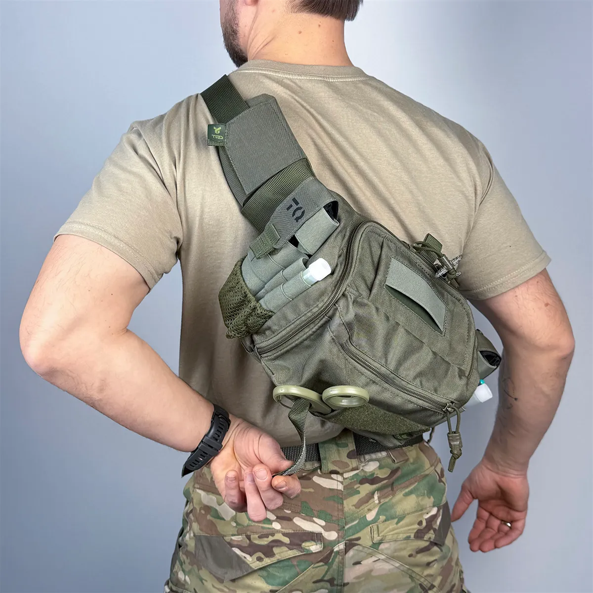 Borsa medica tattica DNIPRO BM33 verde oliva indossata a tracolla in configurazione crossbody