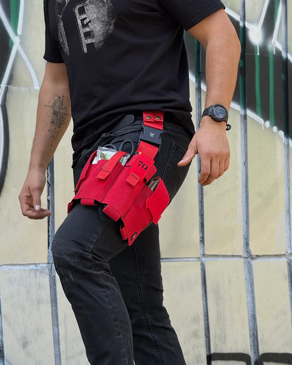 Cosciale medico aperto DNIPRO PM25 GEN2 Rosso indossato durante un'attività operativa con kit di primo soccorso facilmente accessibile.
