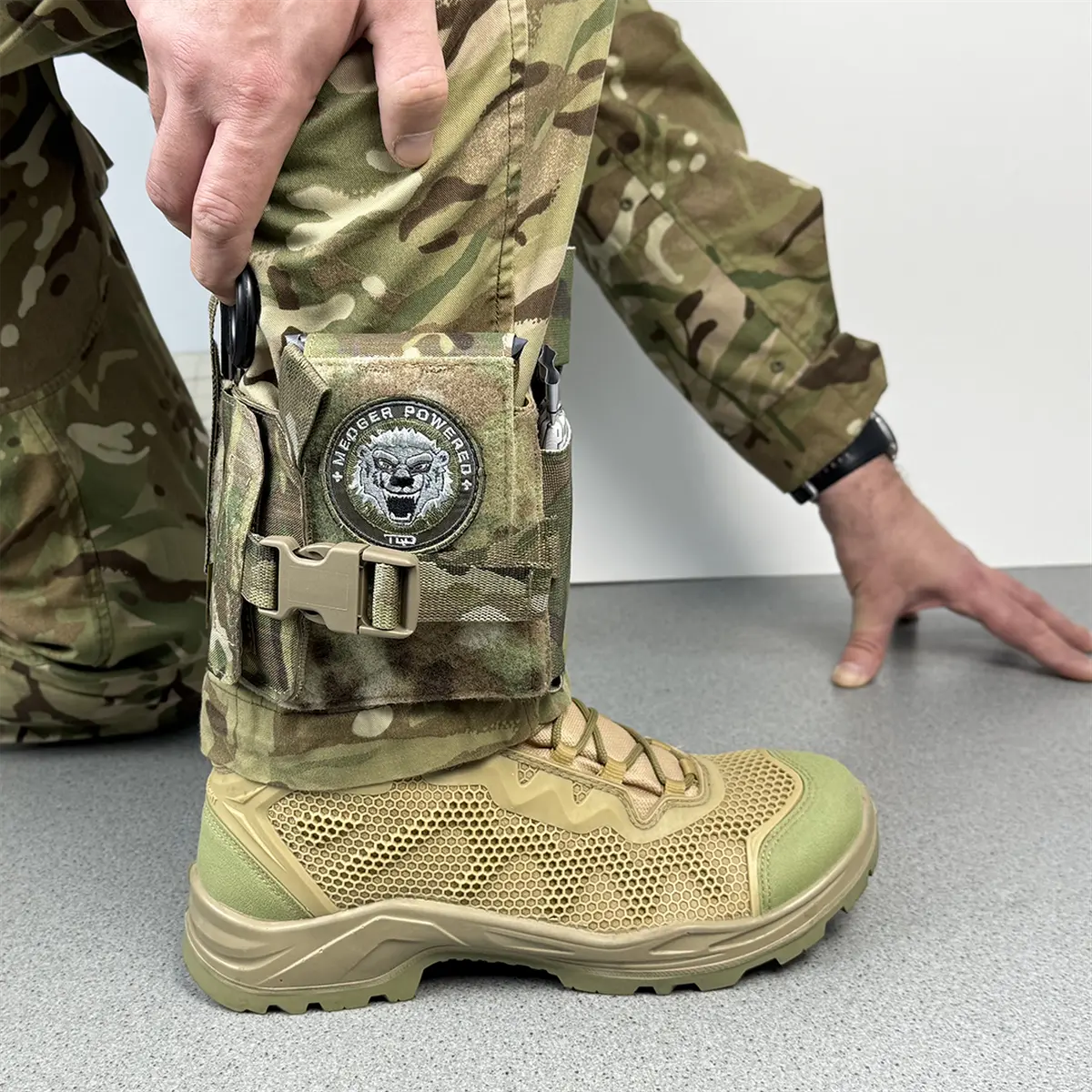 Custodia IFAK da caviglia tattica DNIPRO PM23 in Multicam indossata durante una simulazione operativa, con accesso immediato al kit di primo soccorso individuale.