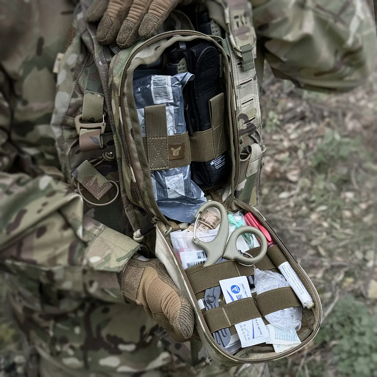 Custodia IFAK DNIPRO PM22 Multicam aperta con kit medico organizzato (contenuto illustrativo non incluso).