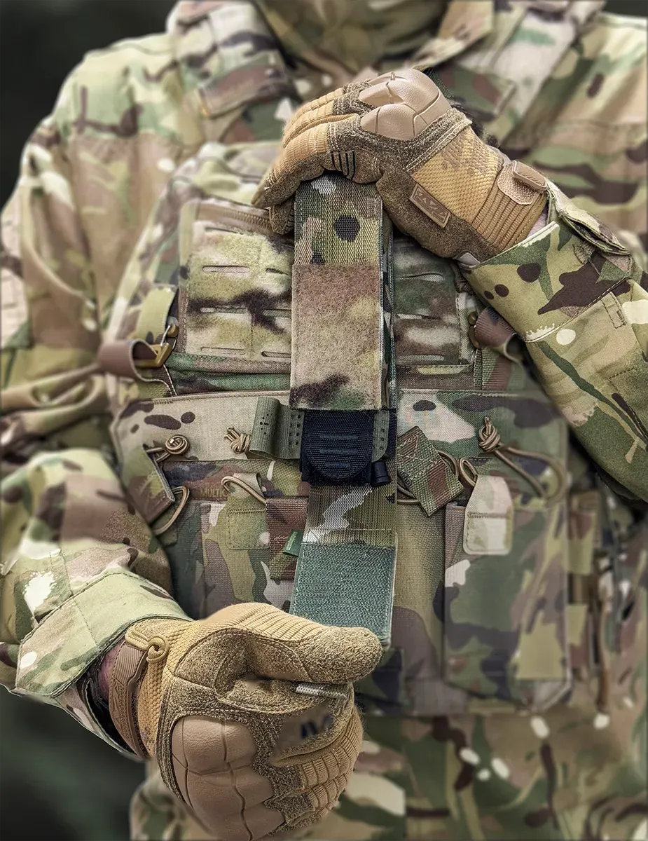 Porta tourniquet tattico DNIPRO PM01 GEN2 Multicam montato frontalmente su plate carrier durante l'impiego operativo