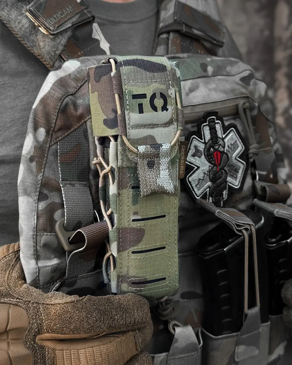 Primo piano del porta tourniquet tattico DNIPRO Gen2 PM03 Multicam montato su equipaggiamento operativo con tourniquet inserito
