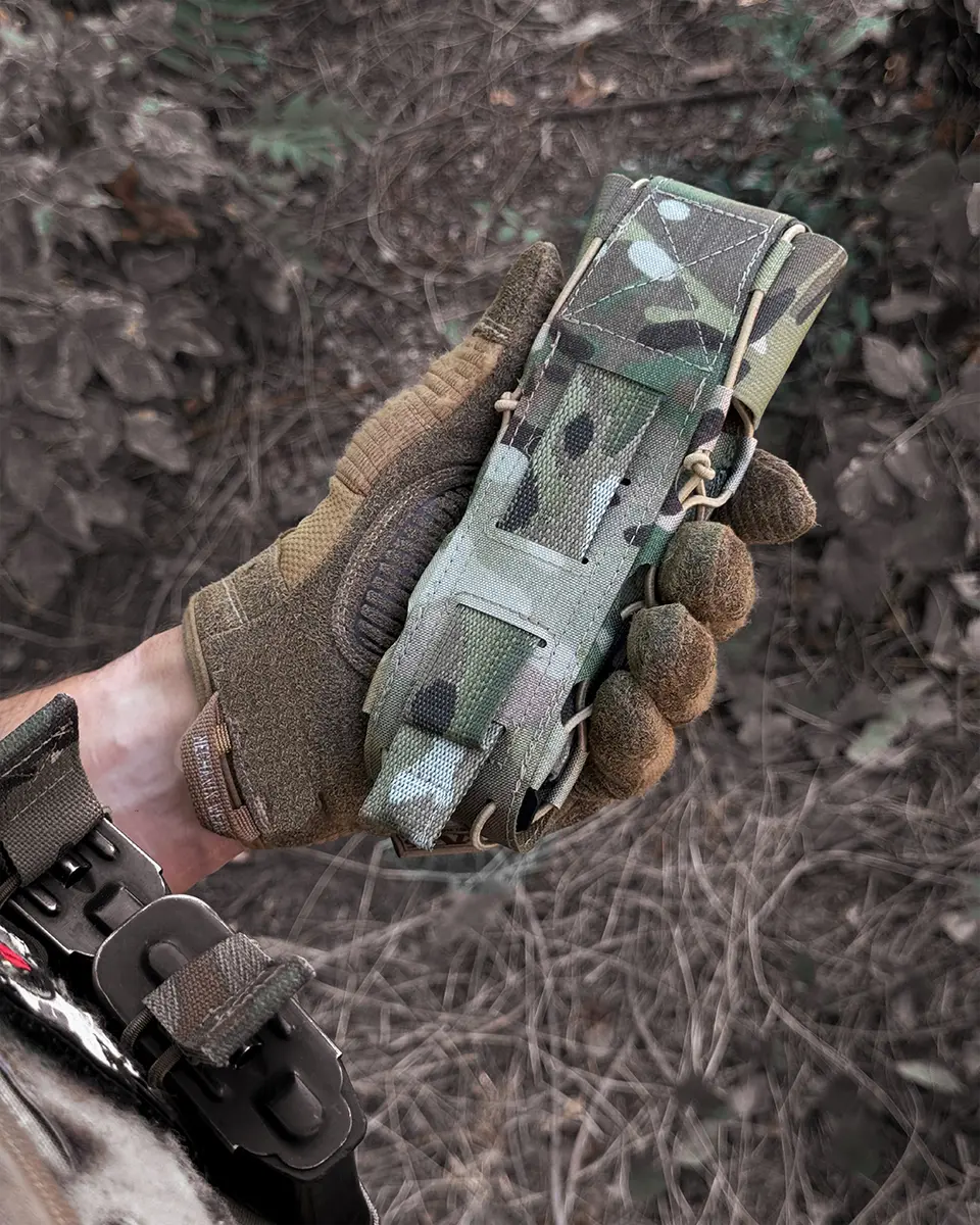 Porta tourniquet tattico DNIPRO Gen2 PM03 Multicam mostrato durante l'utilizzo con vista posteriore montato su equipaggiamento MOLLE