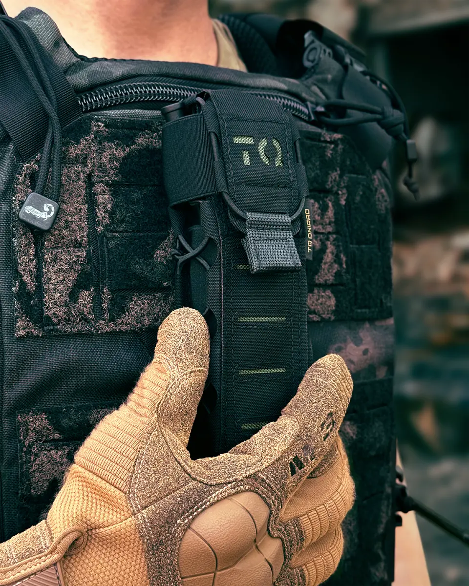 Porta tourniquet tattico DNIPRO Gen2 PM03 nero montato frontalmente su plate carrier durante l'utilizzo operativo