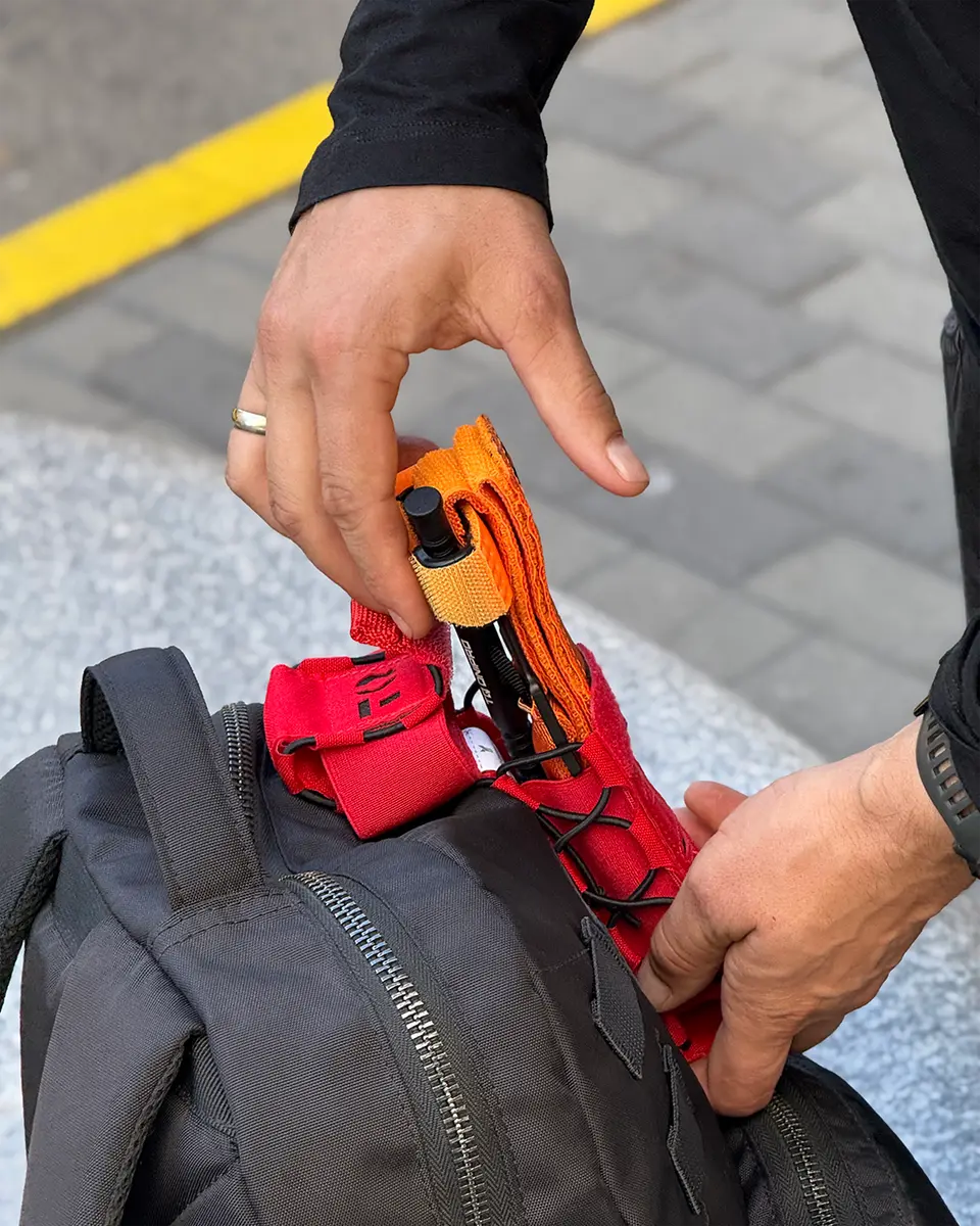 Estrazione rapida del tourniquet dal porta tourniquet DNIPRO Gen2 PM03 rosso installato su zaino
