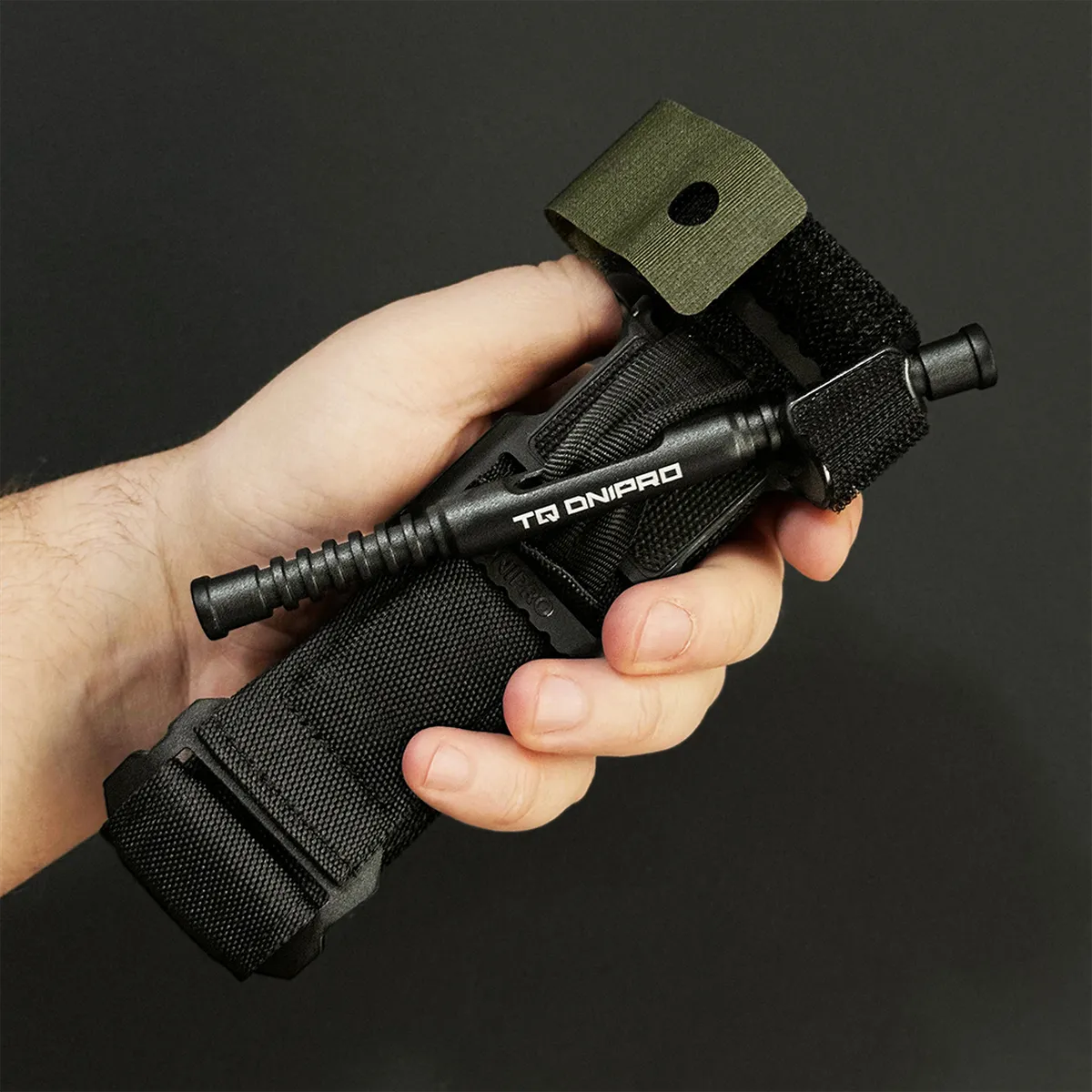 Tourniquet DNIPRO Gen2 nero impugnato in mano per evidenziarne ergonomia e dimensioni