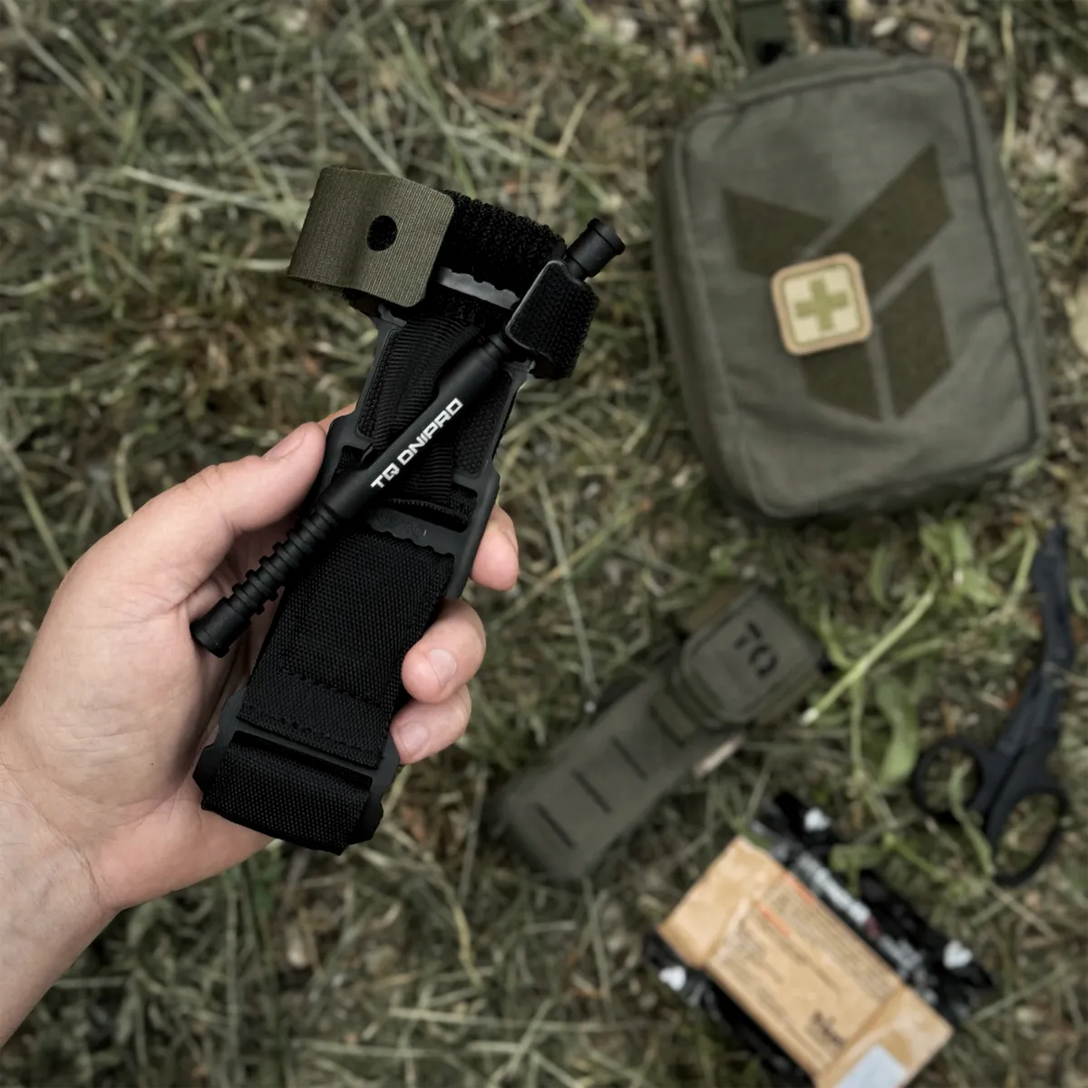 Tourniquet DNIPRO Gen2 nero tenuto in mano durante attività outdoor