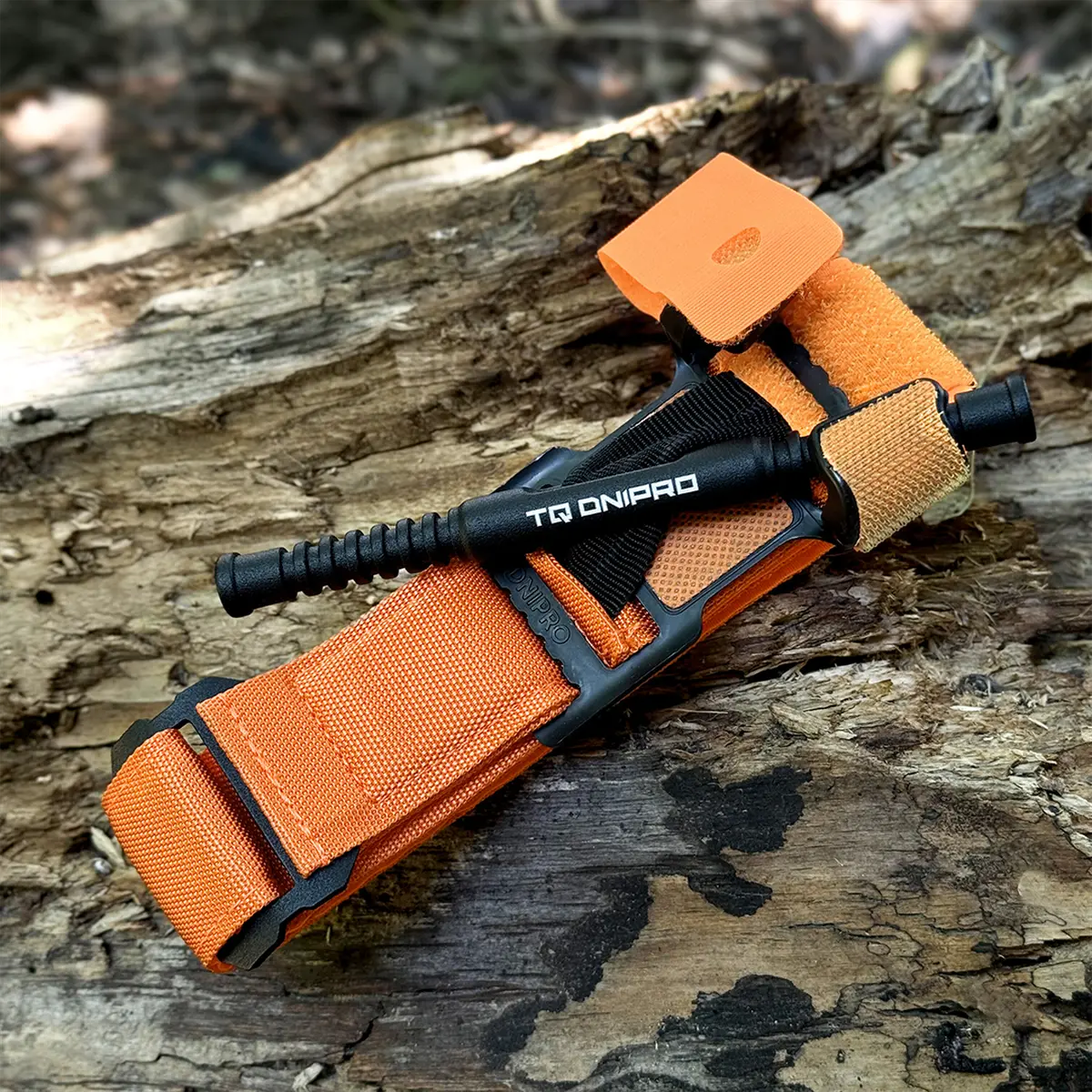 Dettaglio del tourniquet TQ Dnipro arancione ripiegato pronto per il kit di primo soccorso.