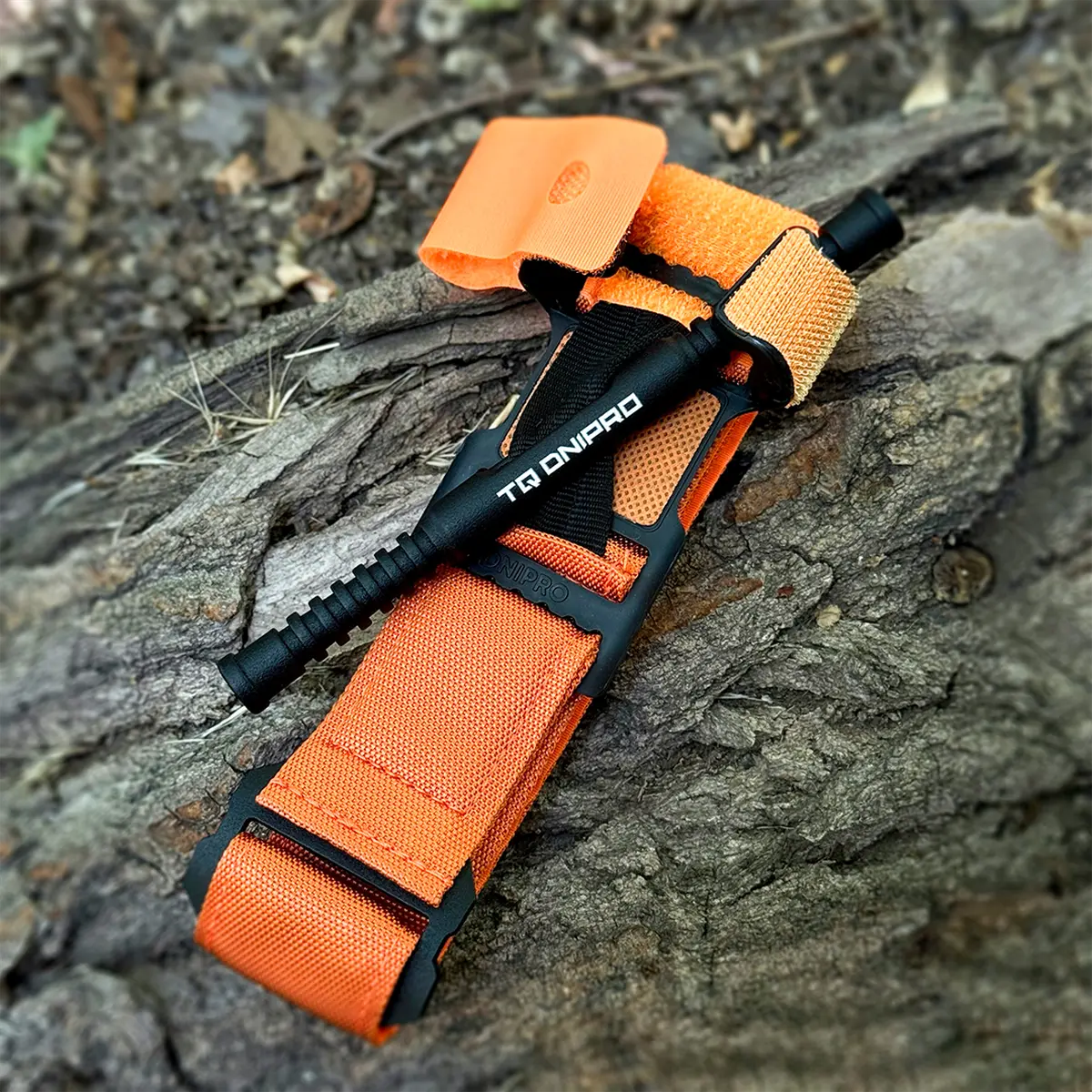Tourniquet TQ Dnipro arancione fotografato frontalmente con windlass in alluminio e chiusura a velcro.