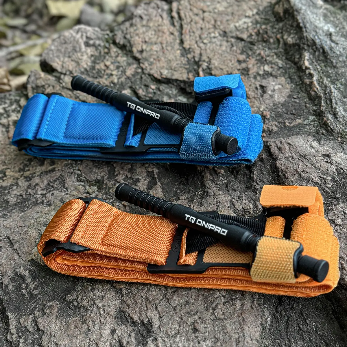 Tourniquet TQ Dnipro arancione ripiegato e pronto all'uso su superficie in legno.
