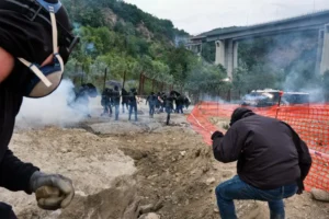 fotoreporter-sicurezza-manifestazioni-07 Manifestante accovacciato tra fumo e barriere durante gli scontri