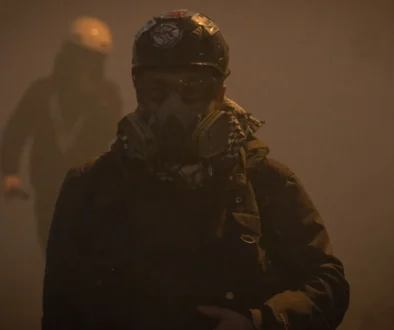 Fotoreporter con casco e maschera antigas durante una manifestazione